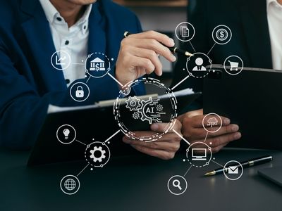 dois homens de bçazer, sendo um cokm tablet na mão e outro com caderno de anotações e caneta.